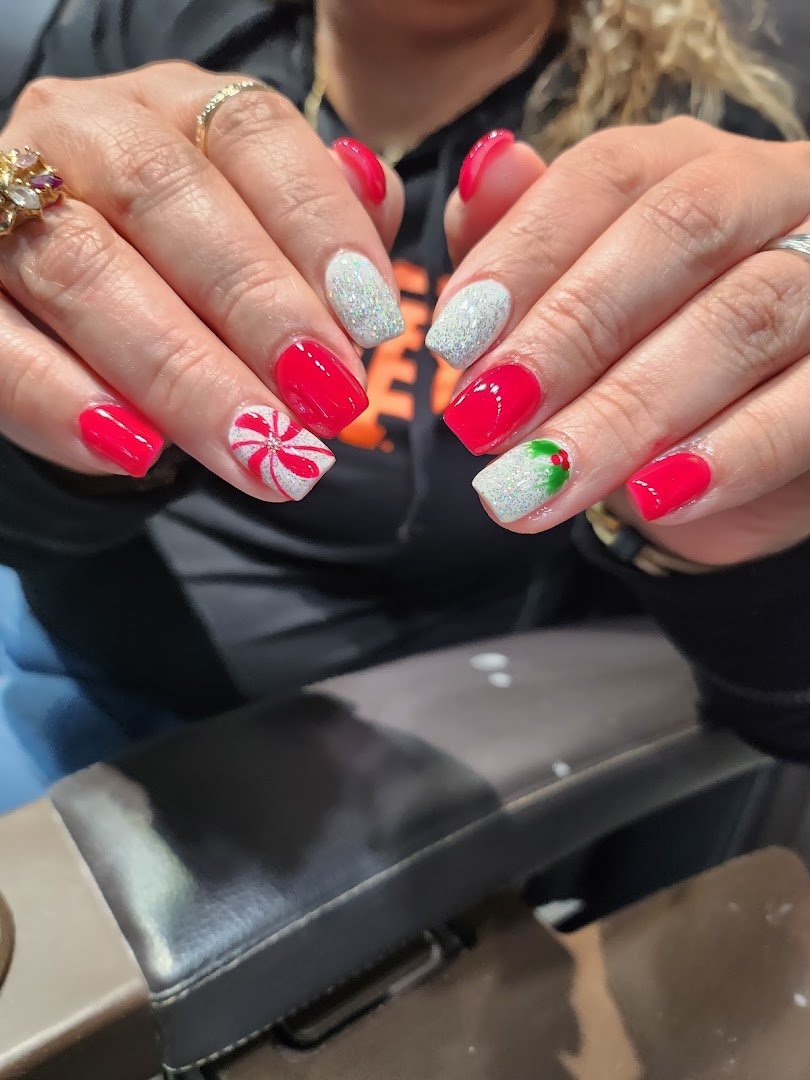Manicured hands beside polish bottles